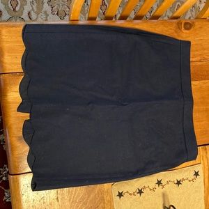 Navy blue skirt with scalloped edging on the bottom.